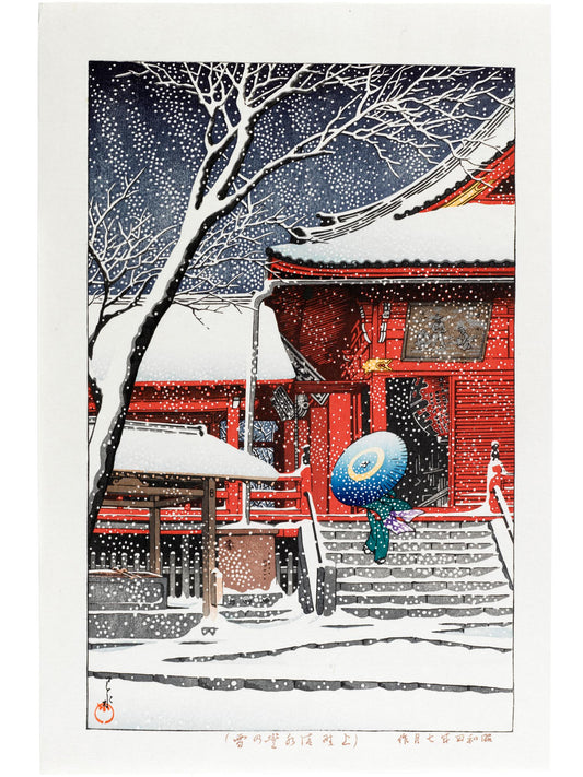 estampe japonaise une femme sous un papapluie bleu, devant entrée temple rouge sous la neige