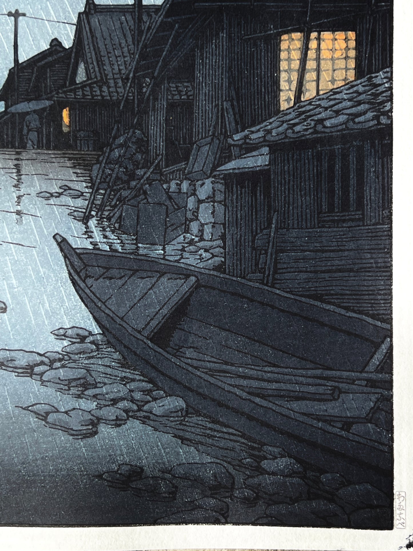 nuit, la pluie tombe sur la rue du village de Kawarako, reflet de l'eau, maisons éclairées, barque en premier plan barque