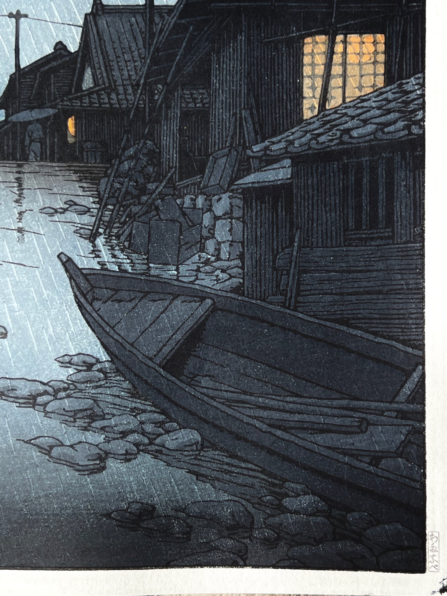 nuit, la pluie tombe sur la rue du village de Kawarako, reflet de l'eau, maisons éclairées, barque en premier plan barque