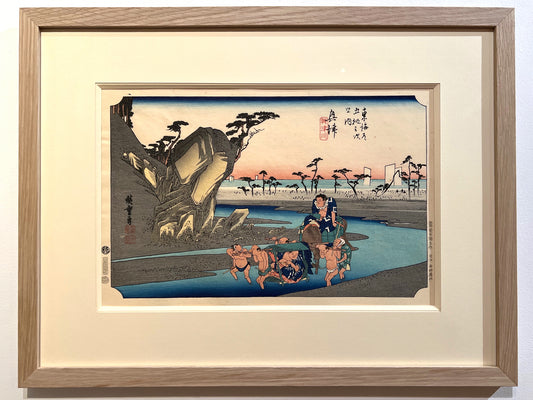 estampe japonaise de paysage de Hiroshige, deux sumos sont portés par quatres hommes sur le chemin inondé du Tokaido, encadré avec un cadre en chene, passe-partout et biseau ivoire