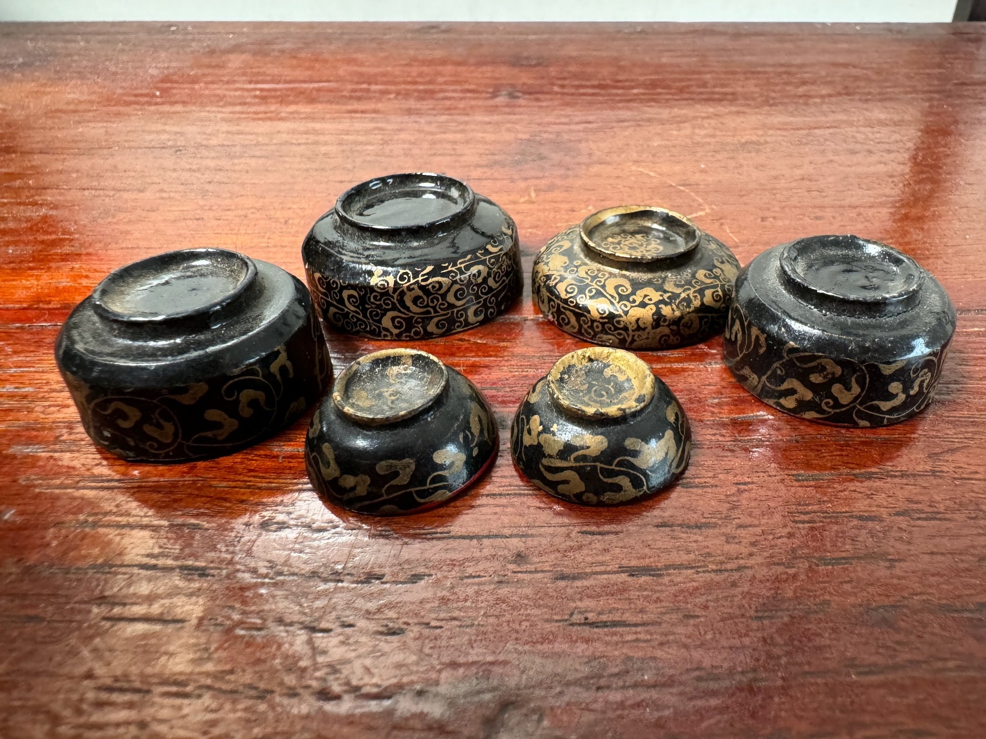 vaisselles japonaises miniature en bois laqué noir et rouge à motifs dorés, vu du dessous