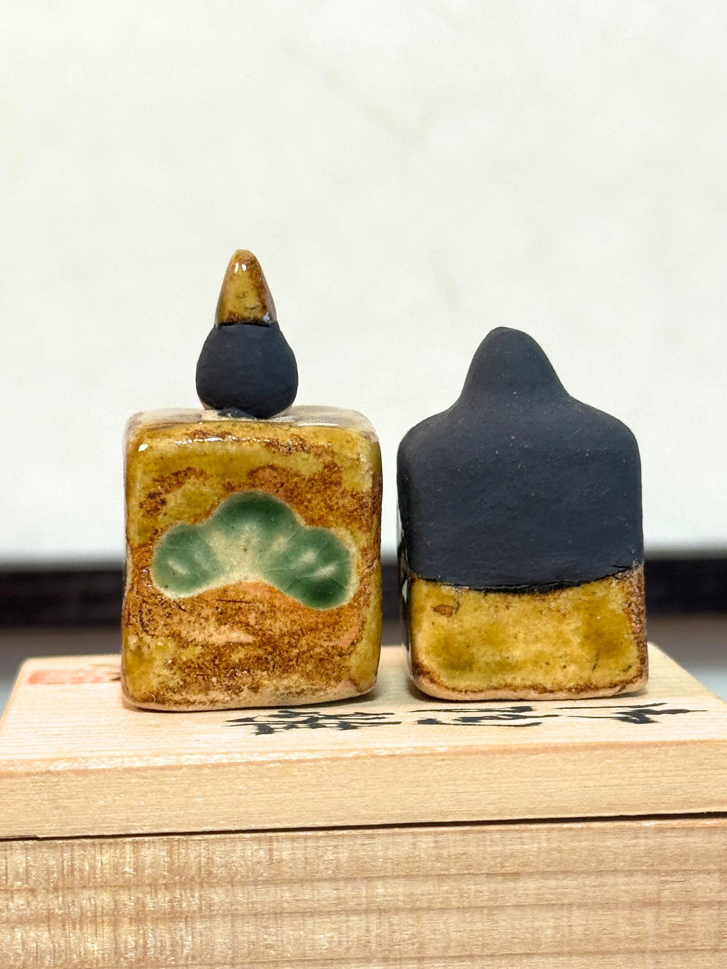 couple de poupées impériales japonaises cubiques en céramique émaillée sur boîte en bois, vu de dos