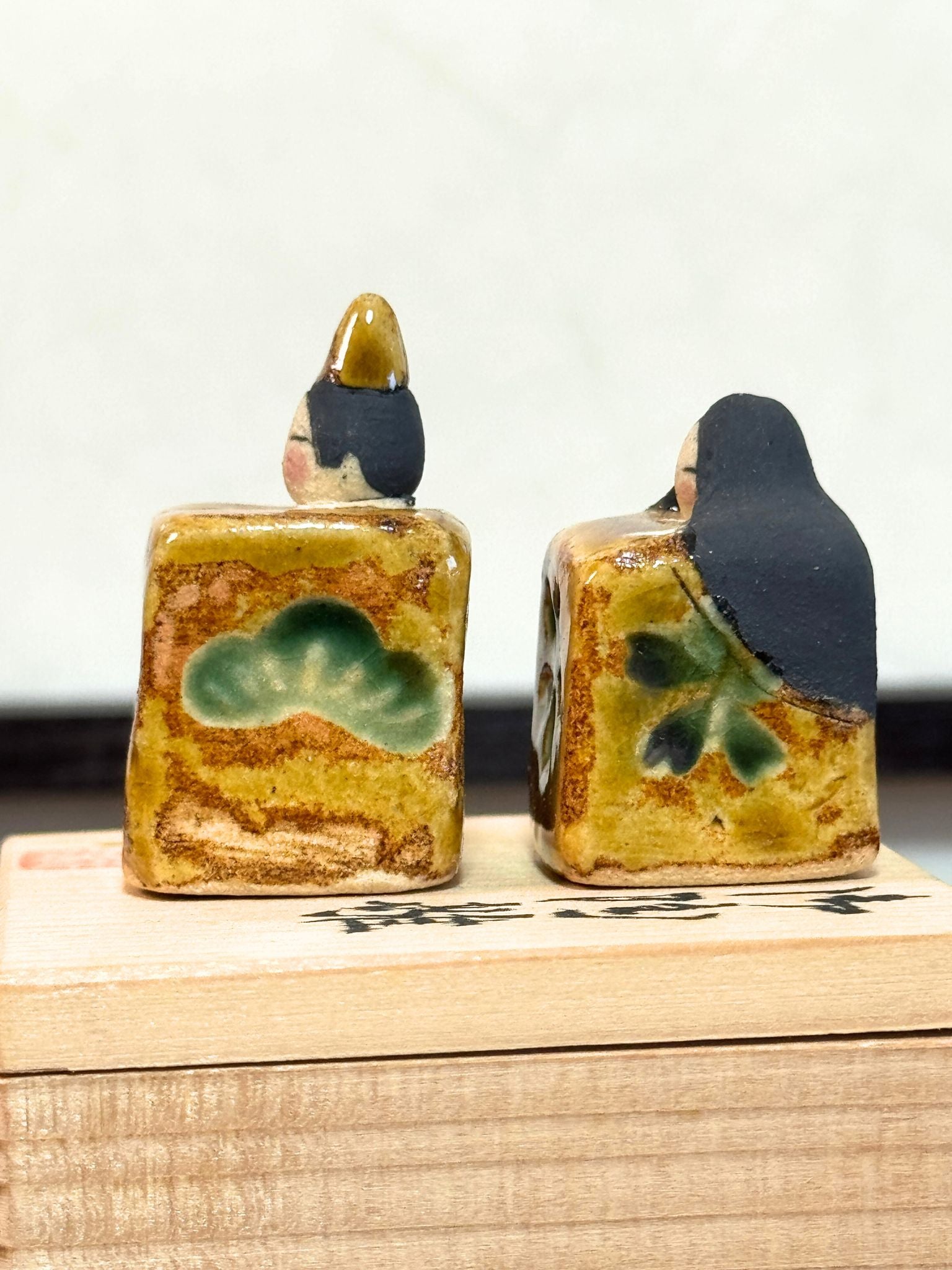 couple de poupées impériales japonaises cubiques en céramique émaillée sur boîte en bois, vu du profil gauche