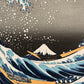 estampe japonaise de Hokusai, la grande vague de Kanagawa, gros plan sur le Mont Fuji et les bateaux