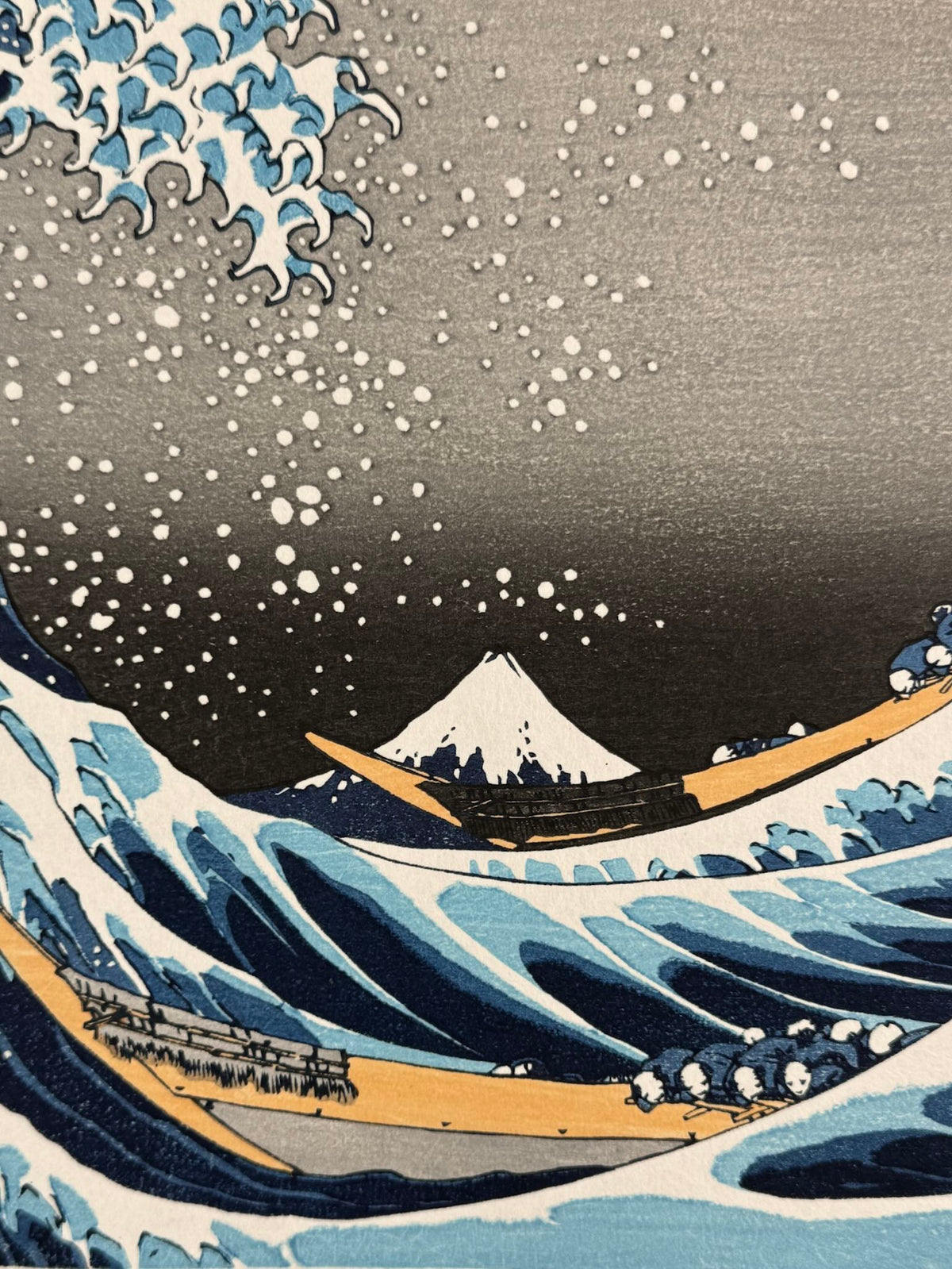 estampe japonaise de Hokusai, la grande vague de Kanagawa, gros plan sur le Mont Fuji et les bateaux