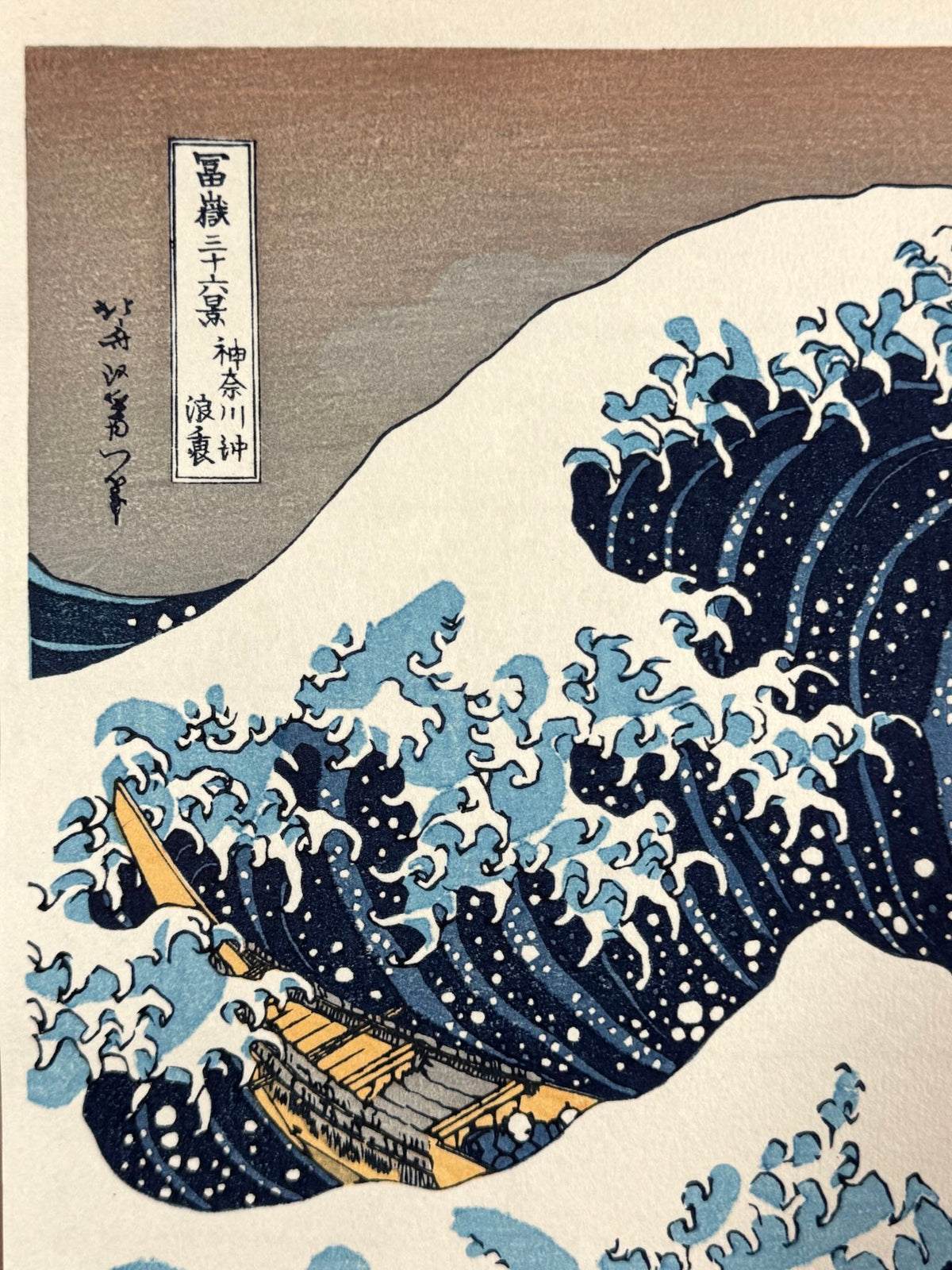estampe japonaise de Hokusai, la grande vague de Kanagawa, gros plan sur le e titre et la signature