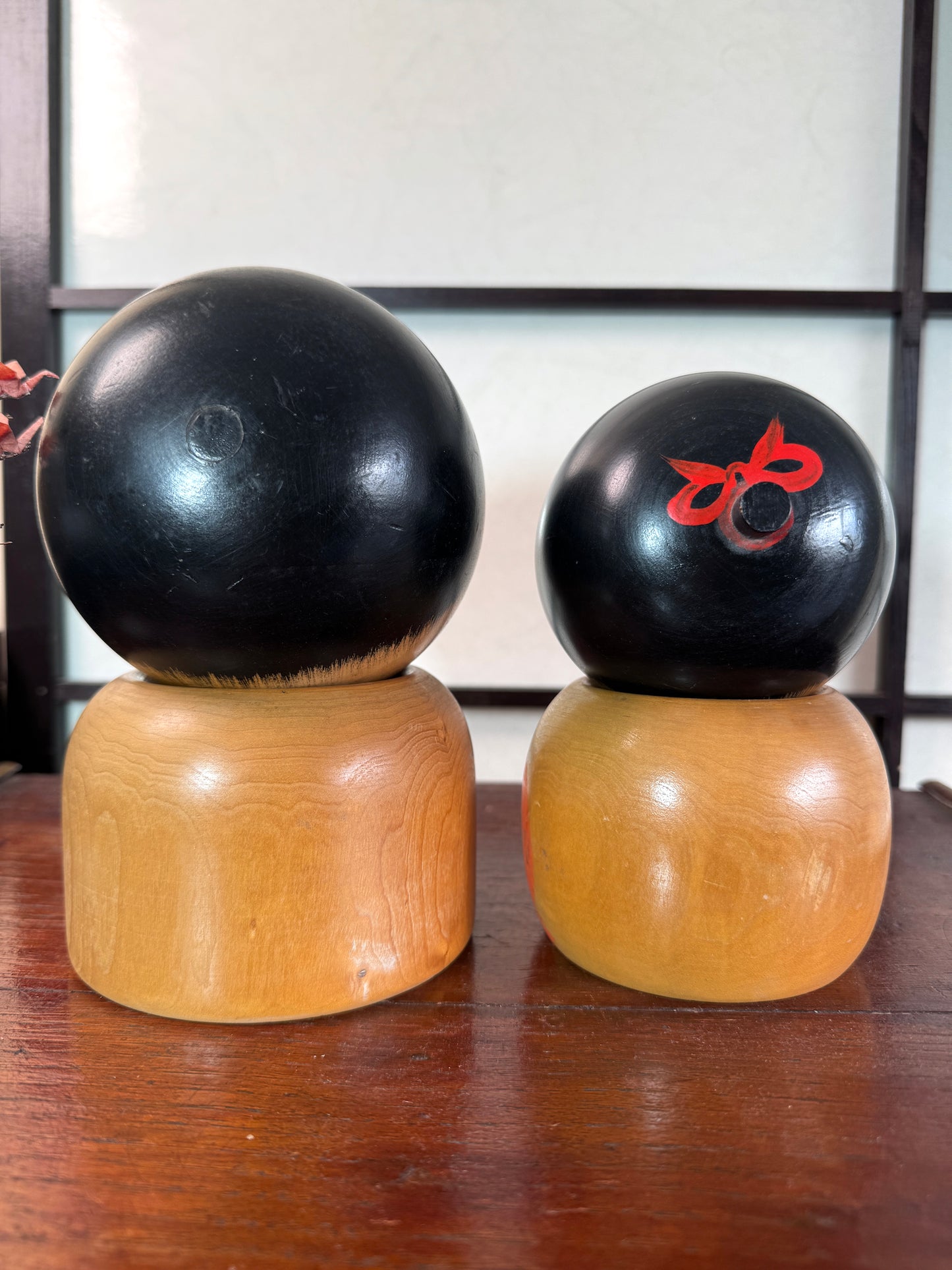 Couple de kokeshi rieuses en bois, calligraphie rouge et verte, signées Sato Kouson, vu de dos