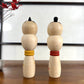 kokeshi, poupée japonaise en bois, couple avec ceinture rouge pour la femme et jaune pour l'homme, vu de dos