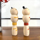 kokeshi, poupée japonaise en bois, couple avec ceinture rouge pour la femme et jaune pour l'homme, profil droit
