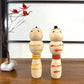 kokeshi, poupée japonaise en bois, couple avec ceinture rouge pour la femme et jaune pour l'homme