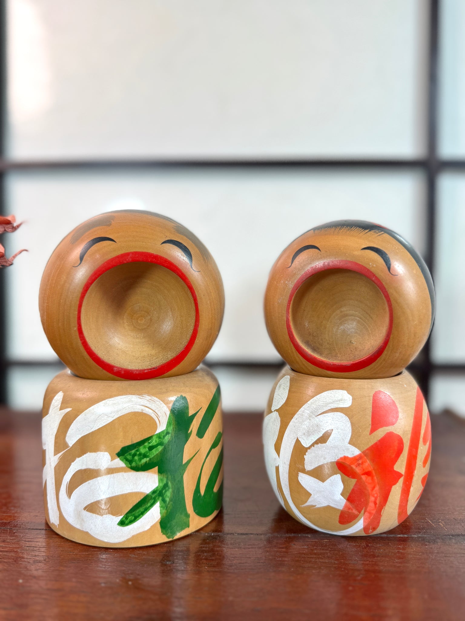 Couple de kokeshi rieuse sato verte et rouge de face
