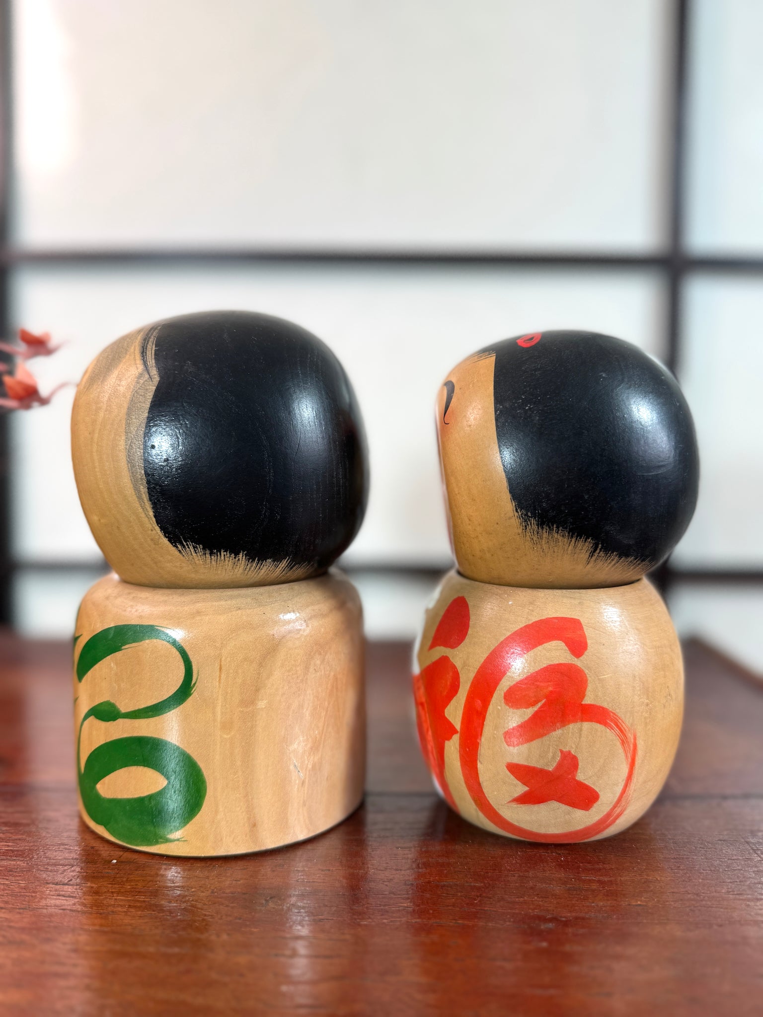 Couple de kokeshi rieuse sato verte et rouge profil gauche