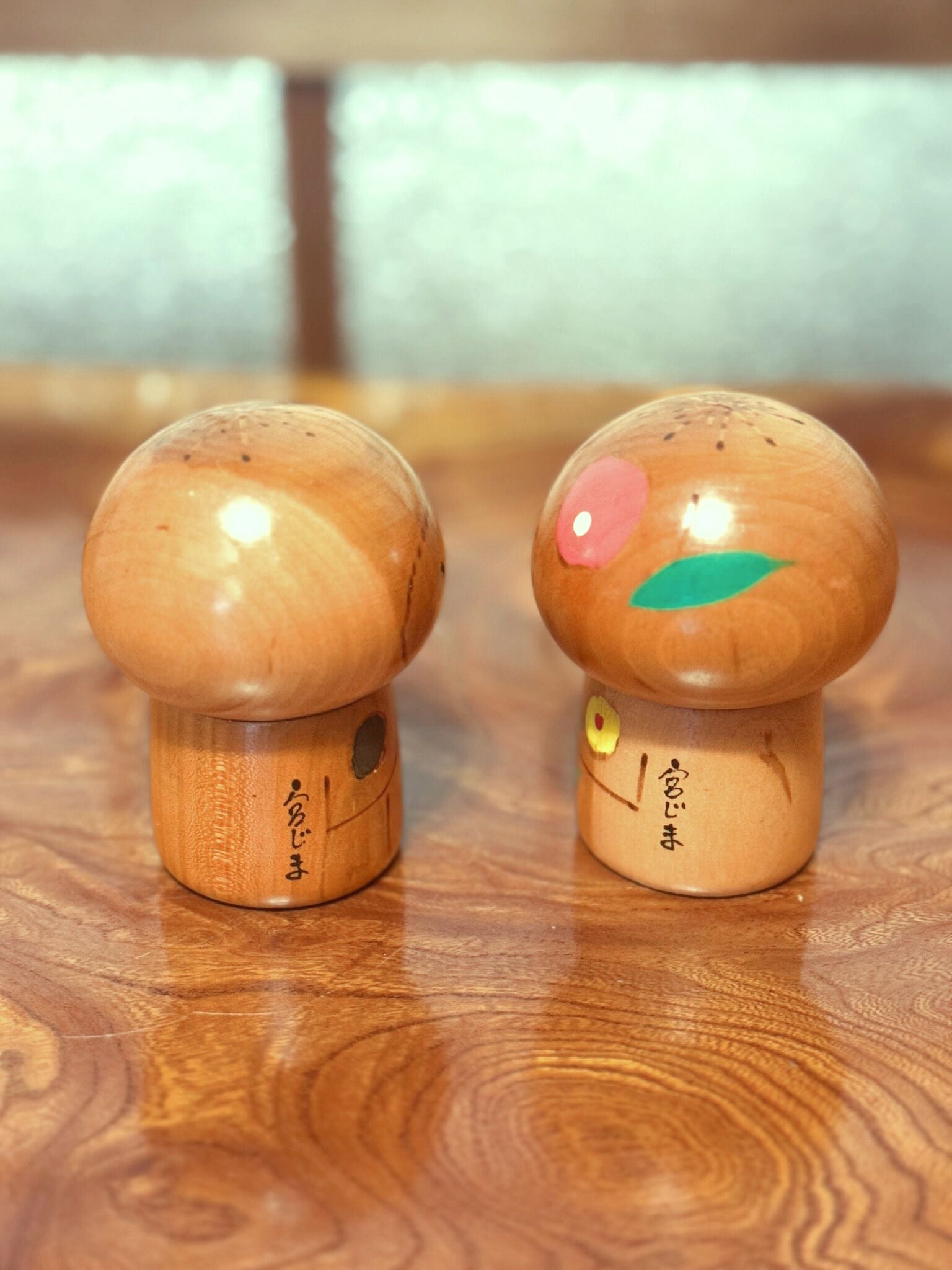 Couple de petites kokeshi en bois peint signées Masashi Takeda de dos