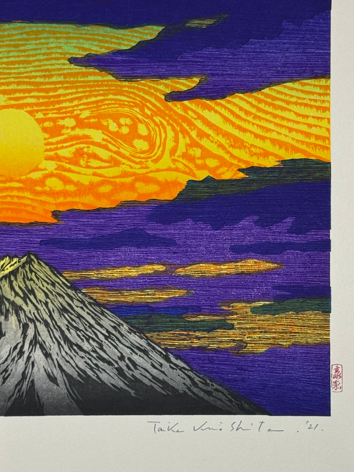 Estampe Japonaise de Kinoshita Taika représentant le soleil dans un ciel jaune aux nuages violets au-dessus le sommet du mont Fuji, détail de la signature et du sceau de l'artiste