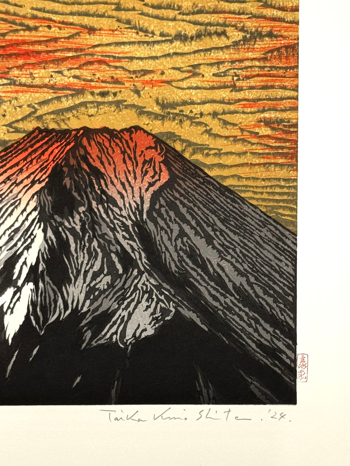 Estampe Japonaise de Kinoshita Taika représentant le sommet du mont Fuji éclairé par un soleil rouge dans un ciel or, détail de la signature et du sceau