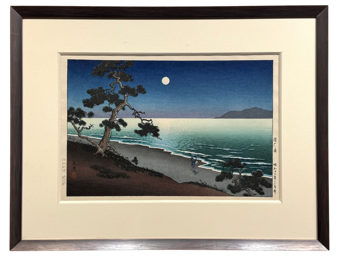 estampe japonaise de Koitsu Tsuchiya la plage de Suma une nuit de pleine lune, une personne marche sur la plage, un pin sur la rive, encadrée avec un cadre en pente argent patiné