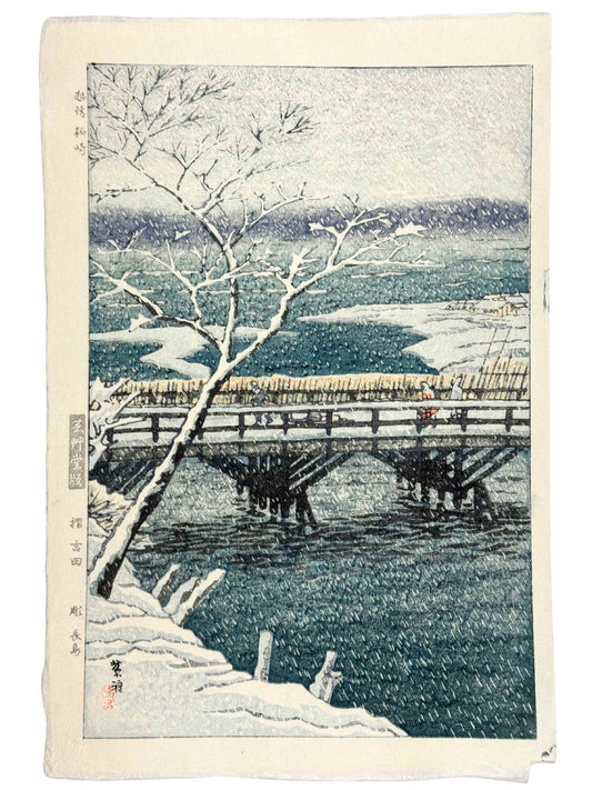 estampe japonaise  de neige de kasamatsu personnage sur un pont en pleine tempête de neige