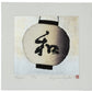 estampe japonaise de Kunio Kaneko représentant une lanterne japonaise ronde et blanche avec l'inscription nagomi en kanji, sur fond or et argent, reflet du fond en pleine lumière