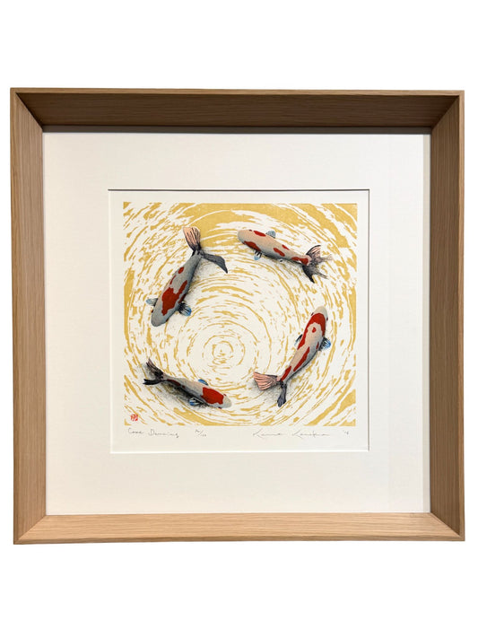Estampe japonaise encadrée de Kunio Kaneko représentant quatre carpes koï dans un mouvement circulaire sur fond jaune et blanc, avec cadre en chêne