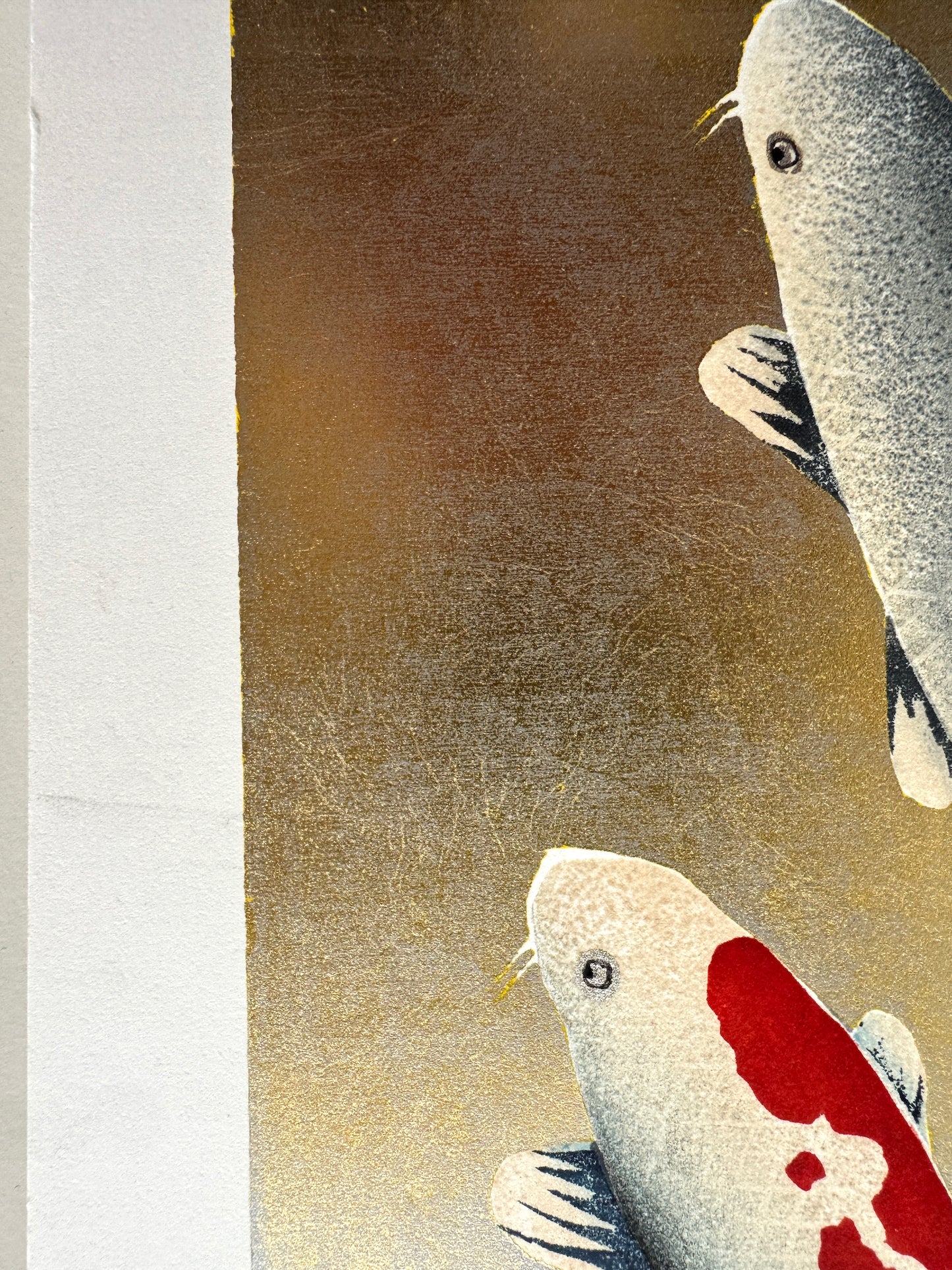 Estampe japonaise de Kunio Kaneko représentant deux carpes koï en sur fond doré et argenté, détail pli dans la marge
