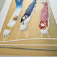 Estampe japonaise avec trois koinobori colorés et un casque kabuto sur fond doré par Kunio Kaneko, vue de profil détail du gaufrage et reflets dorés et argentés