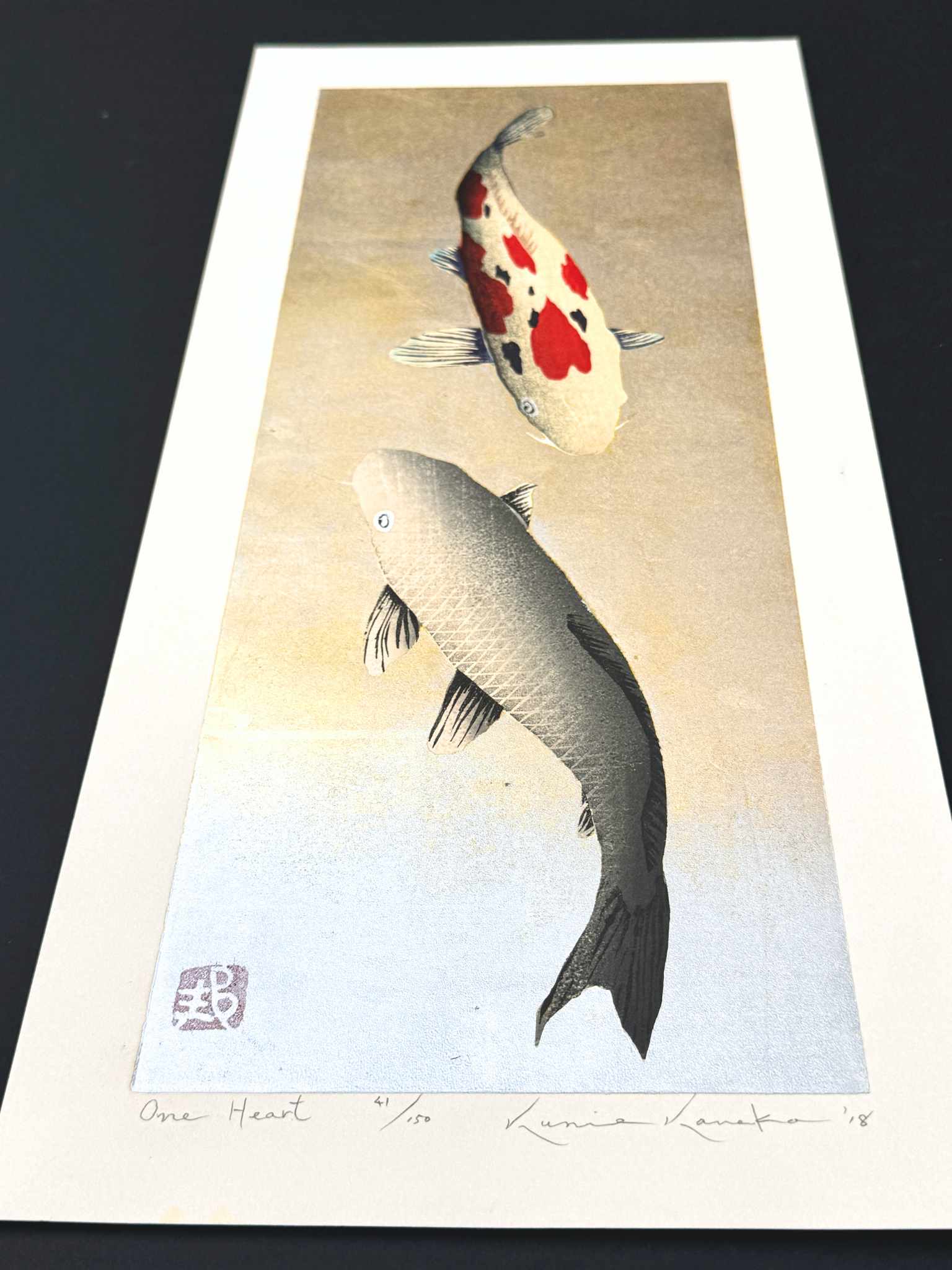 estampe japonaise de Kunio Kaneko, deux carpes Koi, une rouge et blanche et une doré sur fond or et argent, de profil le reflet lumineux du fond