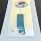 estampe japonaise contemporaine de Kunio Kaneko, une clochette furin avec poisson rouge et vague sur fond or et argent, de profil le reflet