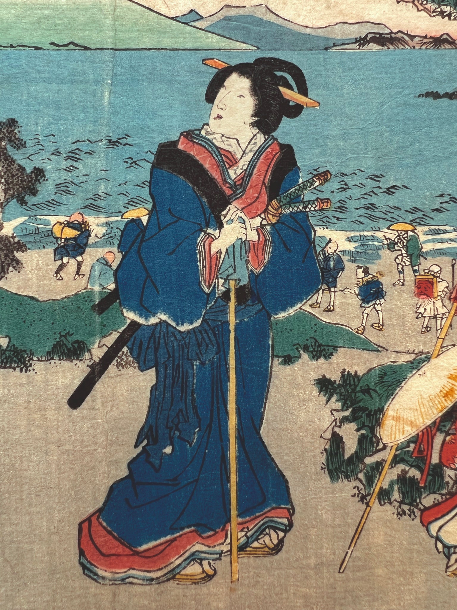 Le voyage de la mariée, une courtisane en kimono bleu avec canne et sabre