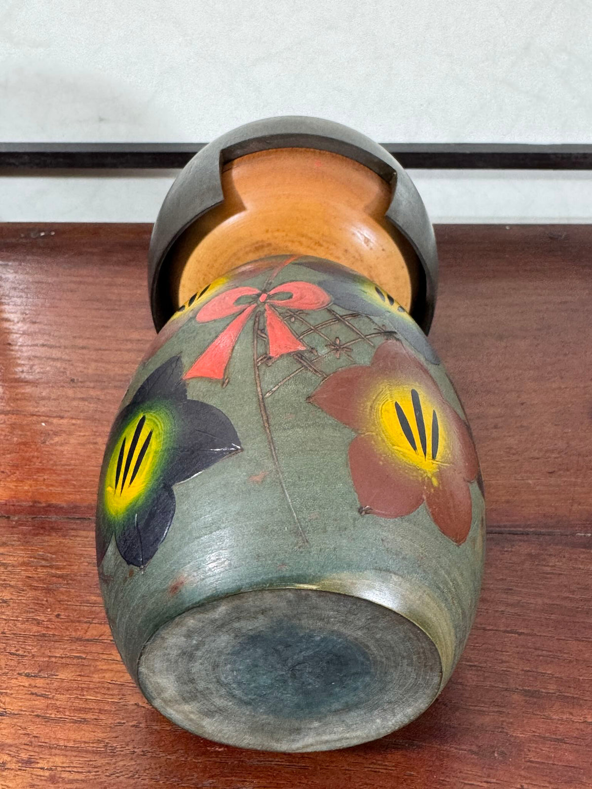Kokeshi vintage japonaise de Yuji Kawase, au kimono vert orné de fleurs campanules colorées gravées et peintes, période Shōwa, vu du dessous