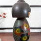 Kokeshi vintage japonaise de Yuji Kawase, au kimono vert orné de fleurs campanules colorées gravées et peintes, période Shōwa, vu du profil droit