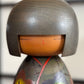 Kokeshi vintage japonaise de Yuji Kawase, au kimono vert orné de fleurs campanules colorées gravées et peintes, période Shōwa, gros plan du visage