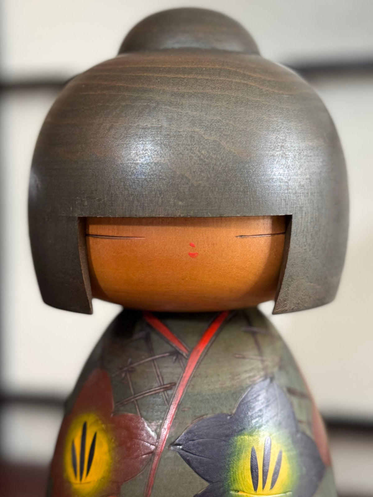 Kokeshi vintage japonaise de Yuji Kawase, au kimono vert orné de fleurs campanules colorées gravées et peintes, période Shōwa, gros plan du visage