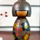 Kokeshi vintage japonaise de Yuji Kawase, au kimono vert orné de fleurs campanules colorées gravées et peintes, période Shōwa, vu de face