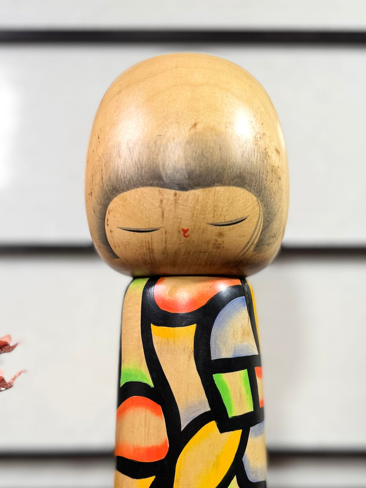 Grande kokeshi vintage de Yuji Kawase, Japon, 31 cm, avec motif vitrail coloré. Gros plan sur le visage