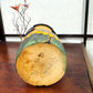 Kokeshi vintage japonaise de Yuji Kawase ornée de grands tournesols jaunes gravés et peints sur fond vert et noir, la signature au dessous