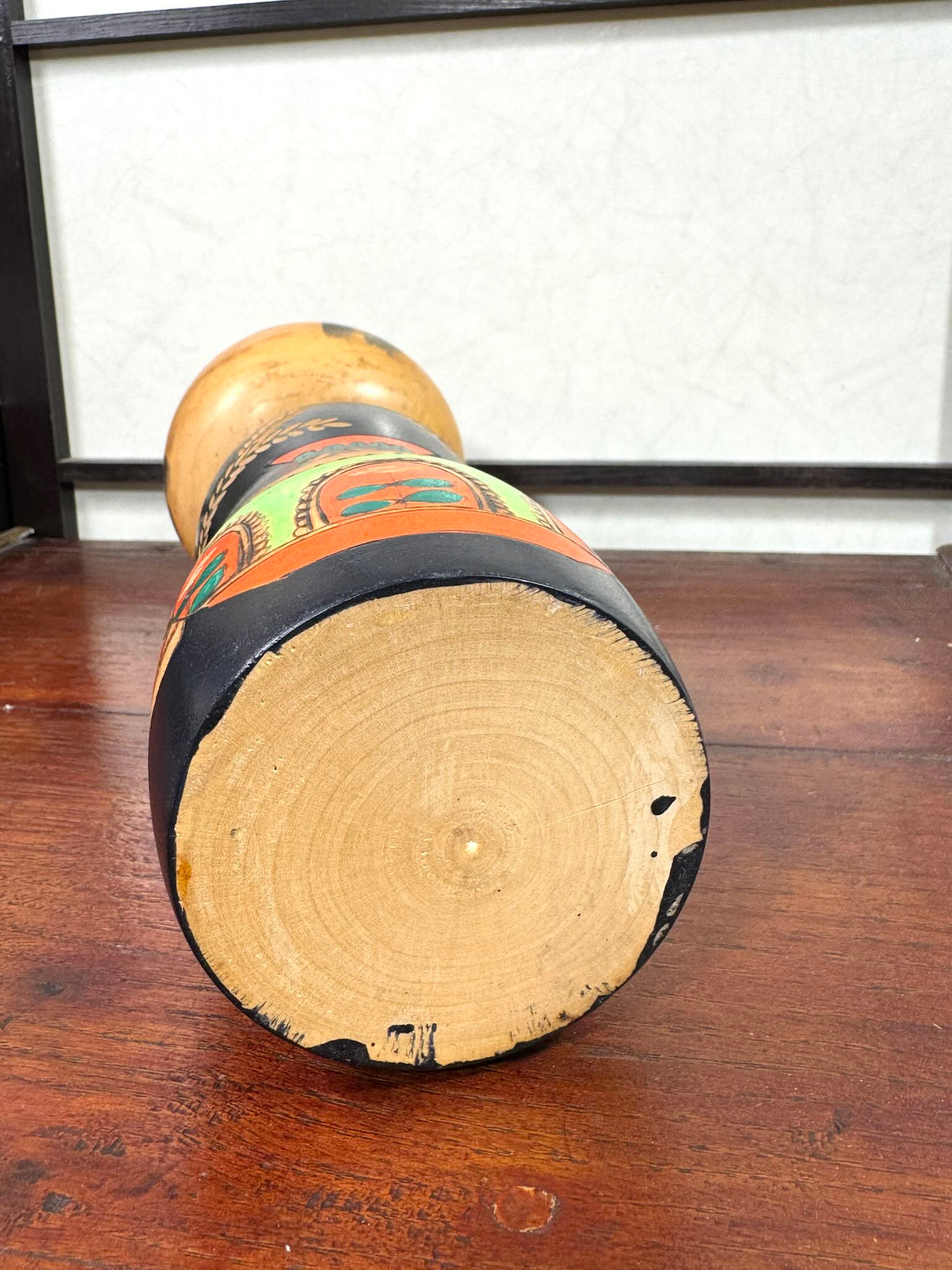 Kokeshi vintage de Yuji Kawase au corps noir décoré d’épis de riz et de deux récipients colorés à motifs géométriques, le dessous