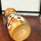 Kokeshi vintage de Yuji Kawase datée de 1985, au petit chignon et kimono orné de fleurs blanches gravées évoquant le cerisier ou le prunier, le dessous