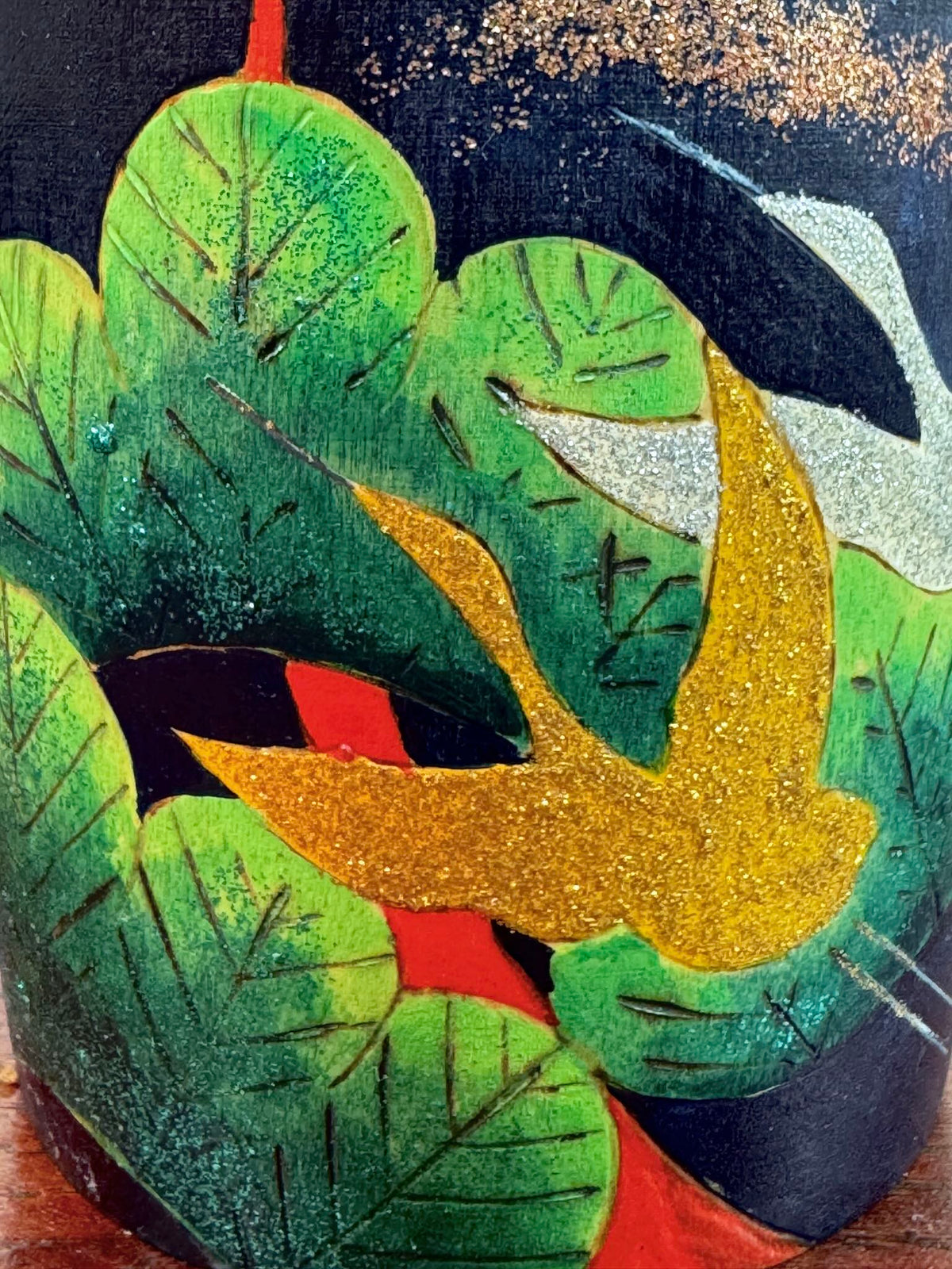 Kokeshi Yuji Kawase décorée de grues et de pins, gros plan sur une grues pailletée or