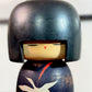 Kokeshi Yuji Kawase décorée de grues et de pins, gros plan sur le visage