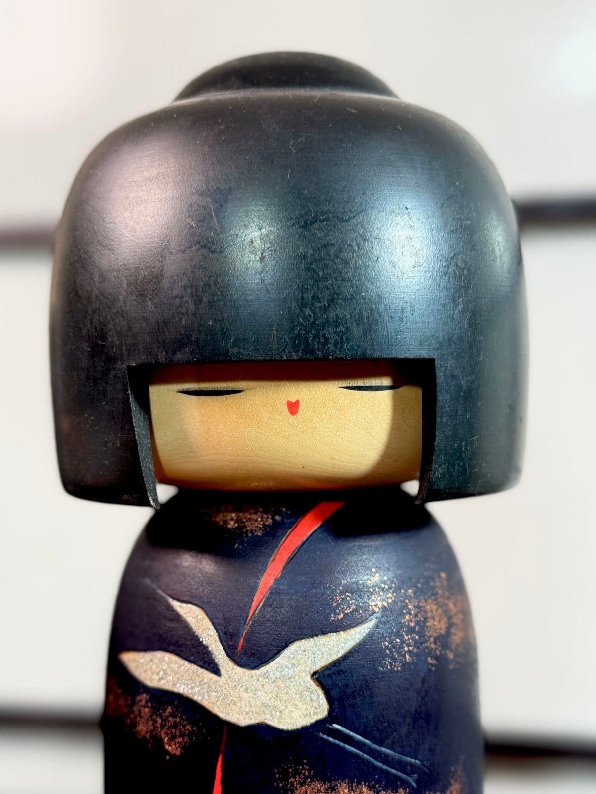 Kokeshi Yuji Kawase décorée de grues et de pins, gros plan sur le visage