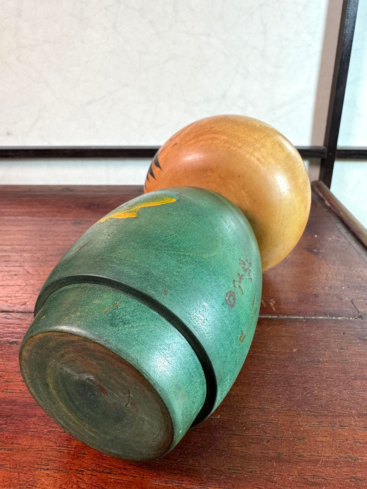 Kokeshi Yuji Kawase verte avec feuilles de vigne d’automne, vu couchée signature au dos