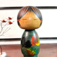 Kokeshi Yuji Kawase verte avec feuilles de vigne d’automne.