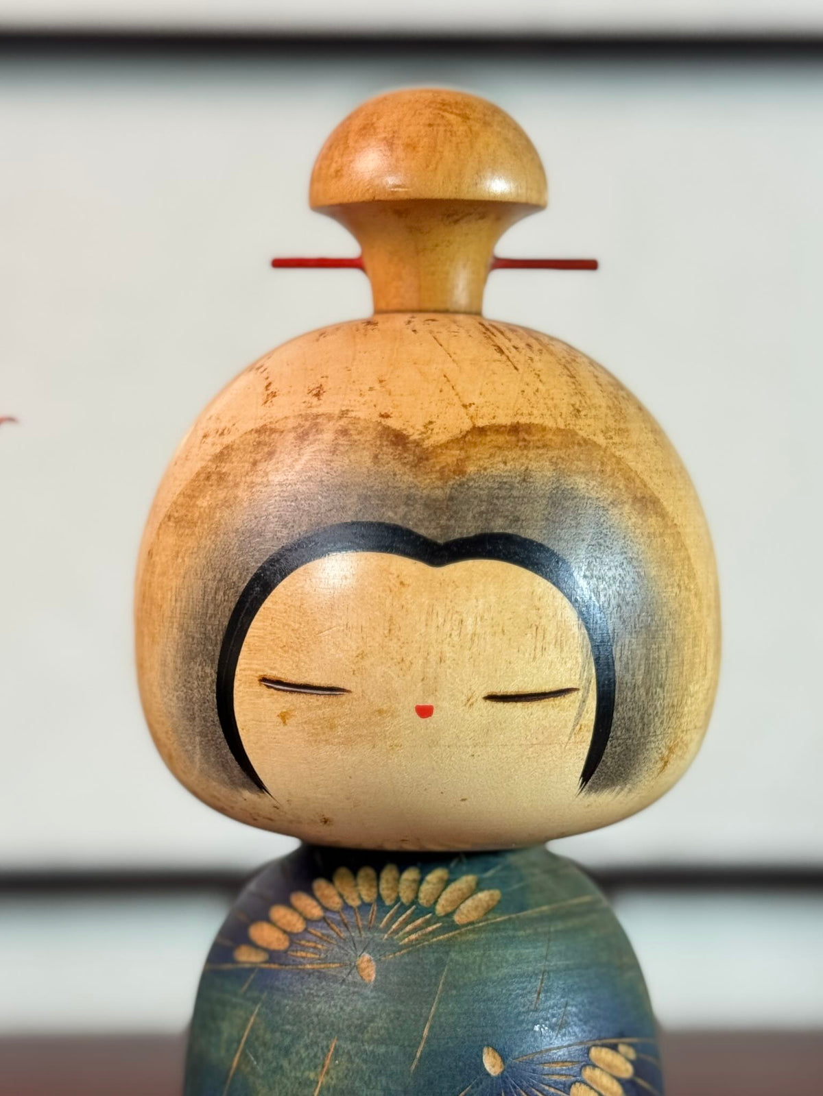 Kokeshi Yuji Kawase bleu-vert avec parapluies gravés et chignon, gros plan sur la tête