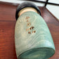 Kokeshi Yuji Kawase Asanoha au kimono vert et bleu, la signature et la date grvées sur le dos