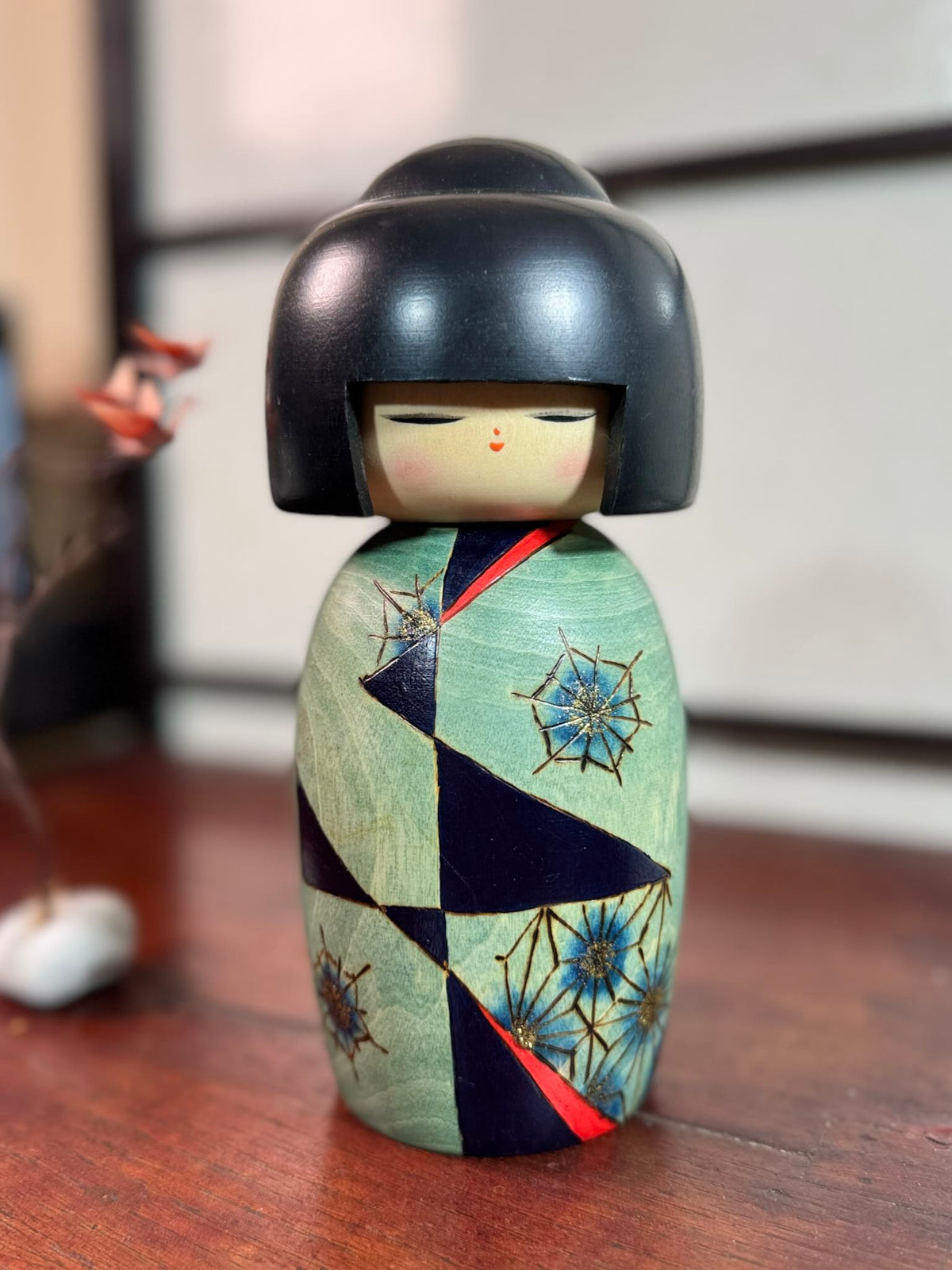 Kokeshi Yuji Kawase Asanoha au kimono vert et bleu.