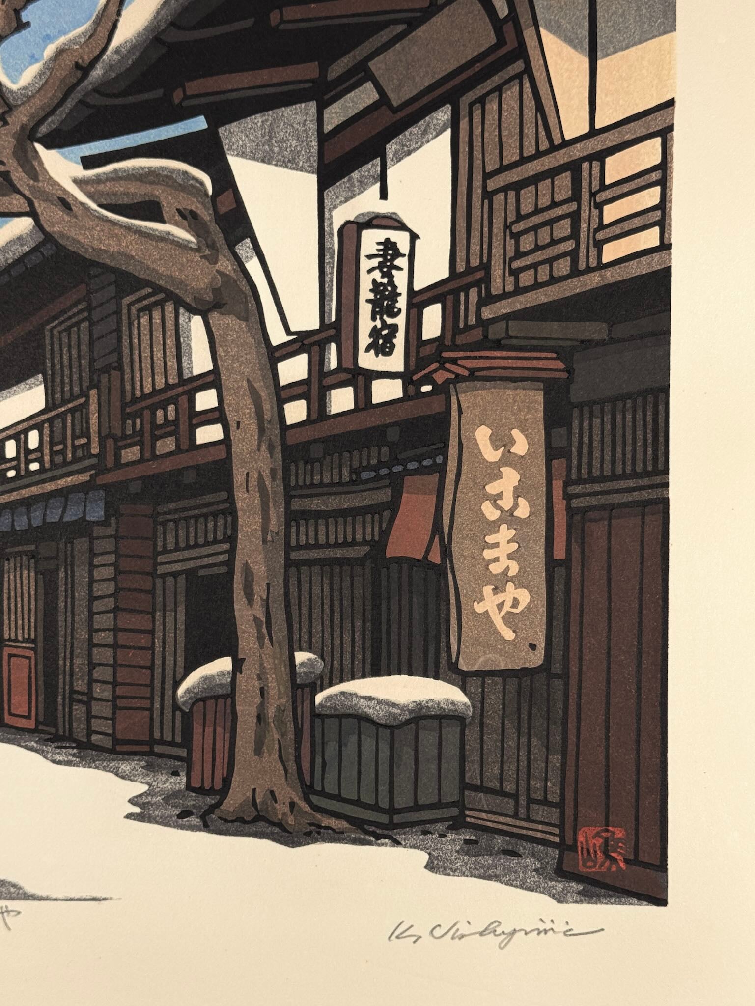 Estampe Japonaise de Nishijima Katsuyuki représentant l'auberge Ikomaya sous la neige dans le quartier historique de Tsumago-juku sur la route du Kisokaidô, détail de la signature au crayon et du sceau