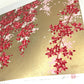 estampe japonaise contemporaine branche de cerisier pleureur avec fleurs rouges et roses sur fond or, reflet de l'or