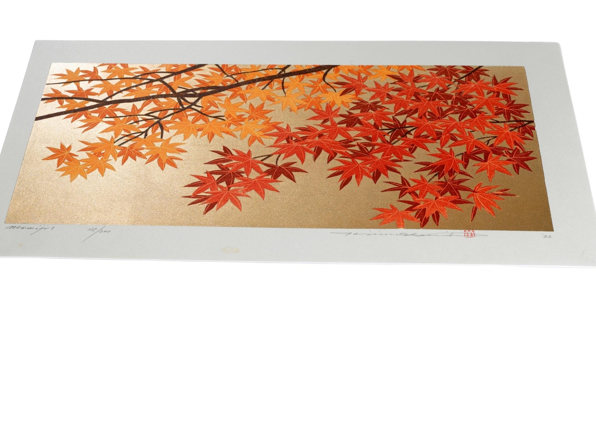 Estampe japonaise de Namiki Hajime, branche d'érables au feuillage jaune et rouge sur fond doré, le reflet du fond vu de profil