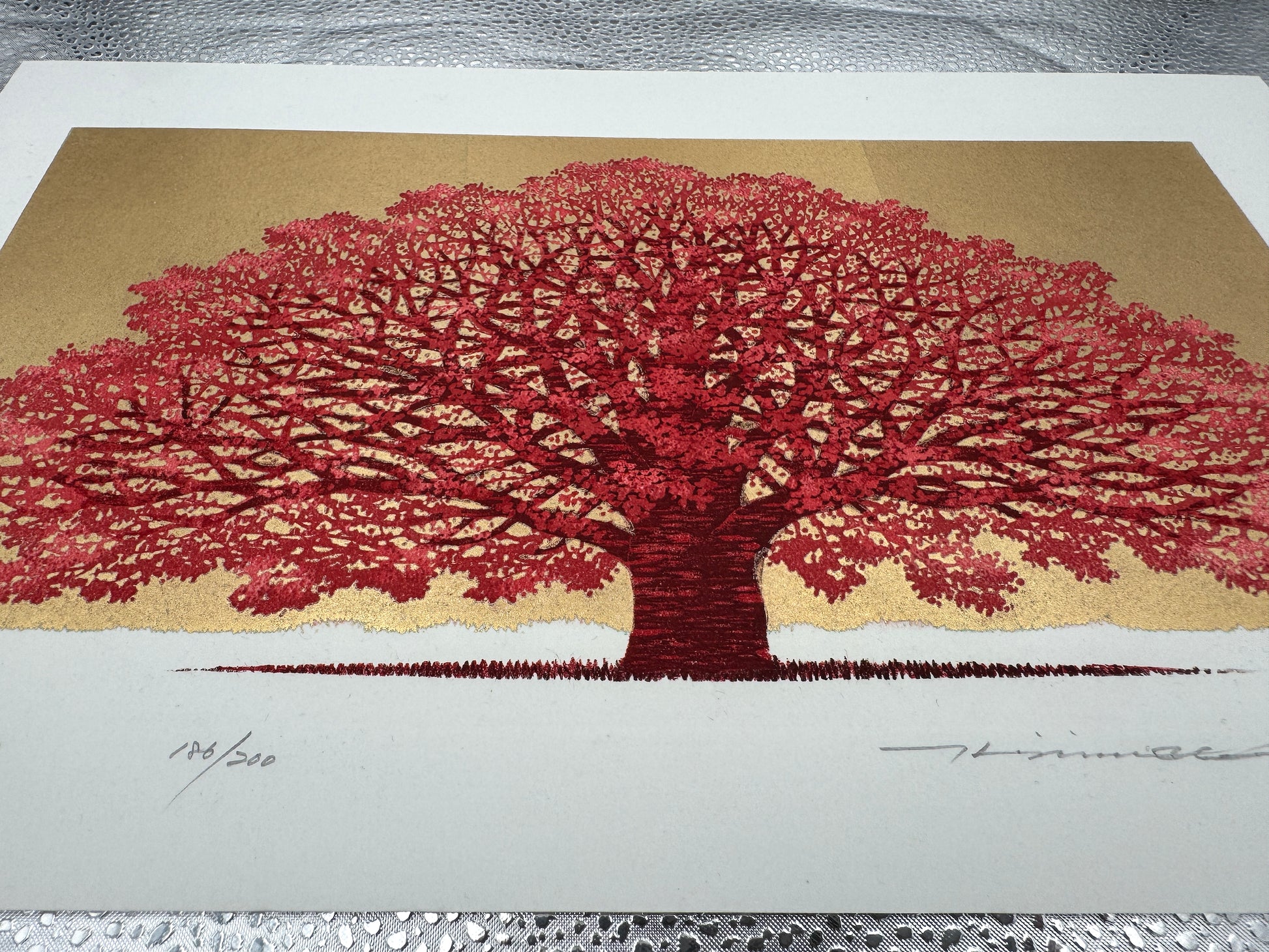 Estampe japonaise de Namiki Hajime représentant un arbre rouge flamboyant sur fond doré, détail des reflets brillants