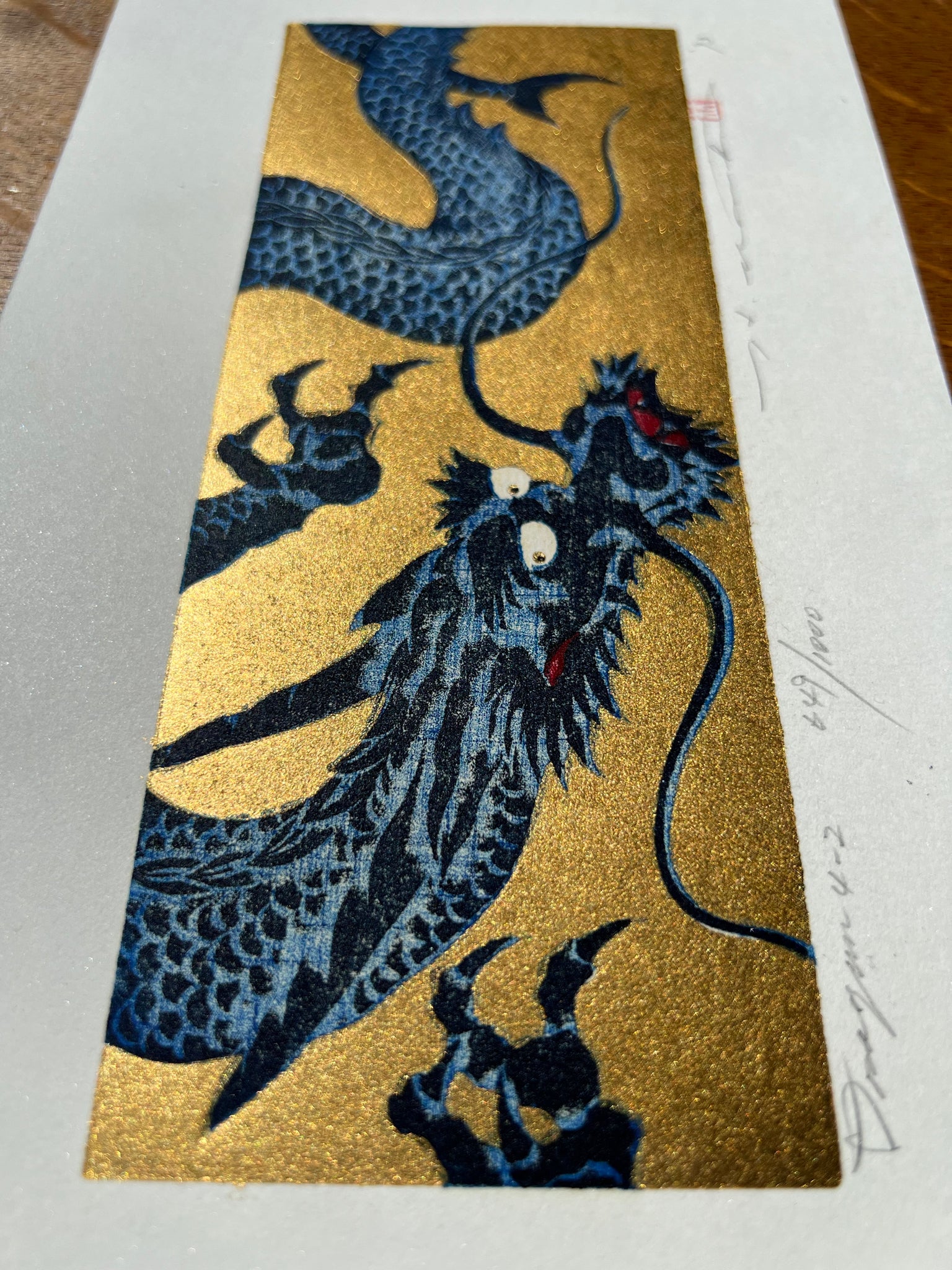 estampe japonaise dragon bleu gueule fermée sur fond or, profil côté tête
